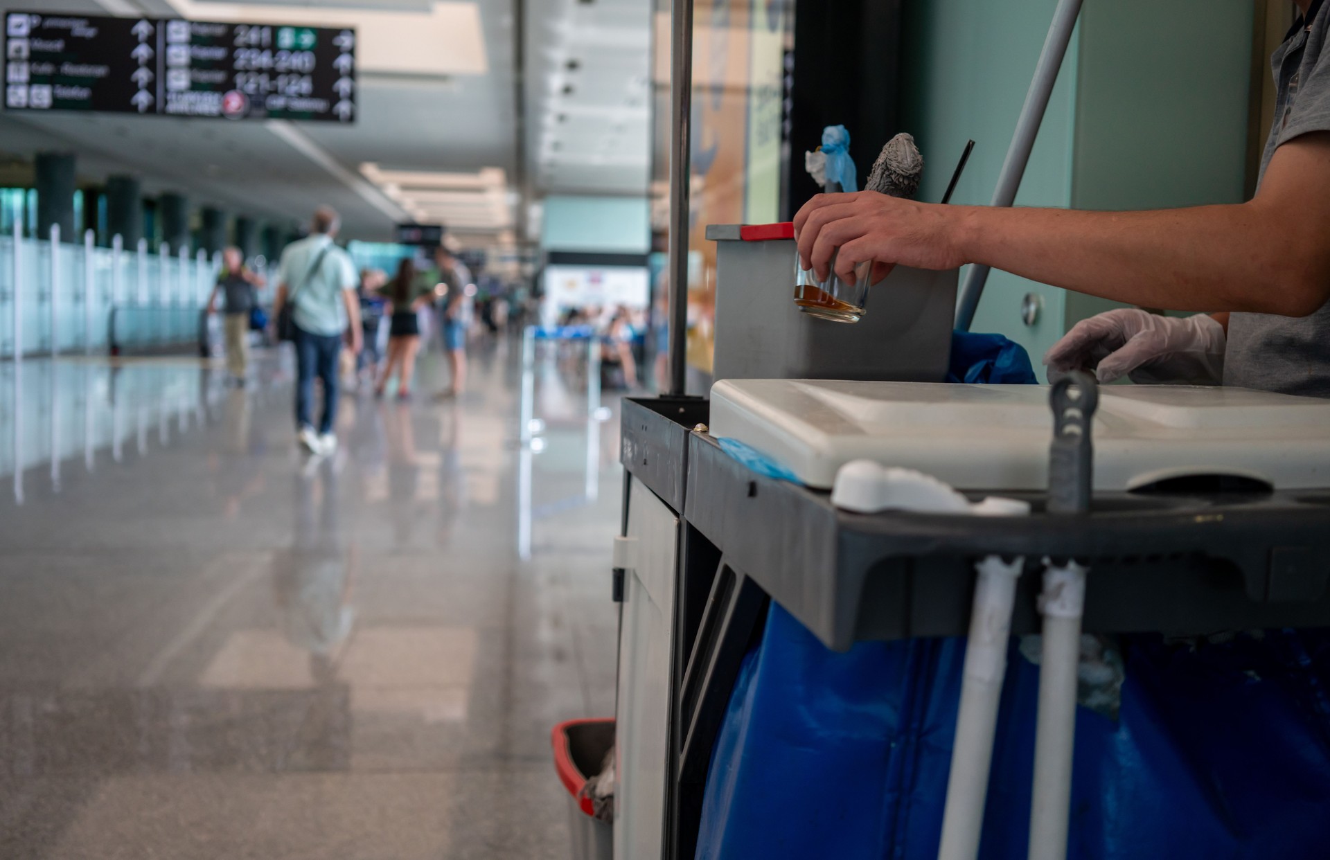 cleaning cart with tools and buckets and a men worker are at airport cleaning service horizontal still