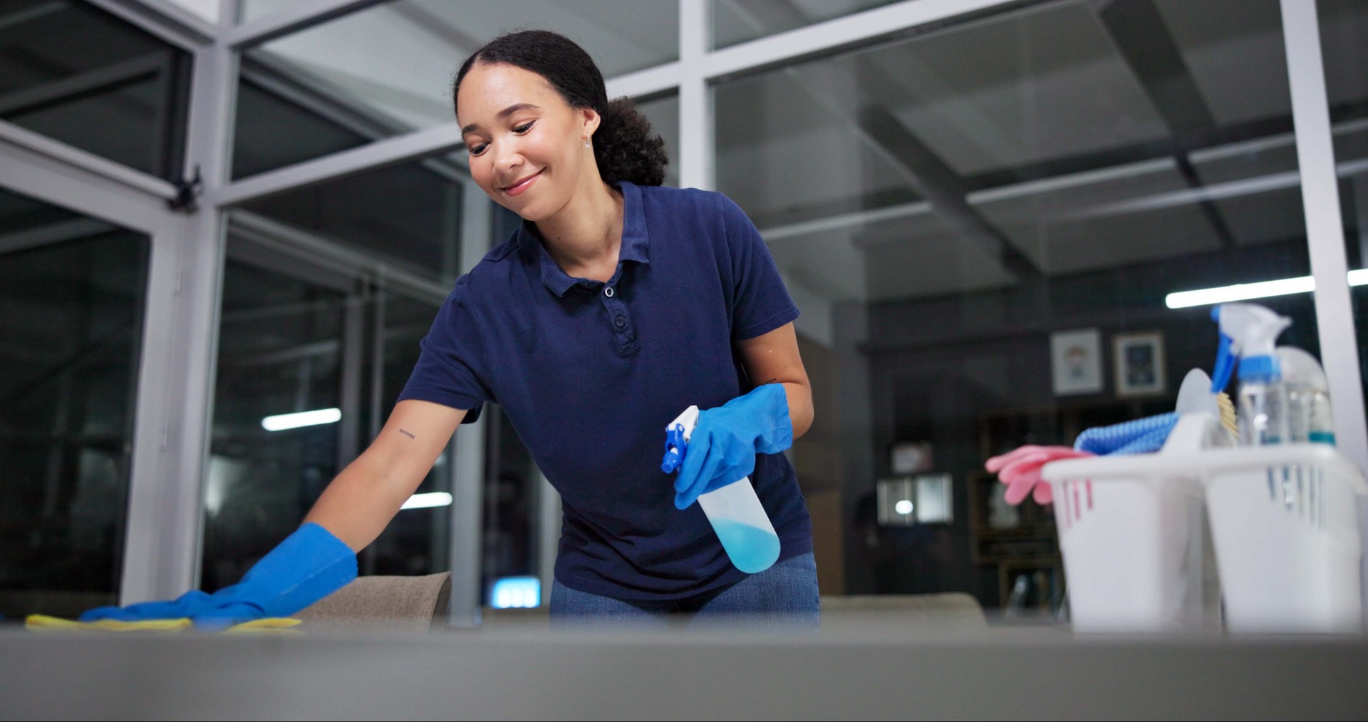 Cleaner, cleaning table woman in office from dust, spray disinfect and protection from disease risk in building. Maintenance, person and chemical liquid for pest control, health and hygiene safety